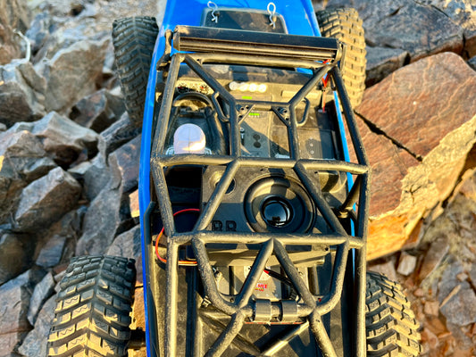The Supreme Single mounted inside the roll cage of a blue RC crawler, seen from directly above. 1/10 scale.