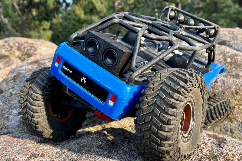 A blue RC crawler climbing granite with The Double mounted behind the cab, seen from above. 1/24, 1/18 and 1/10 scale.