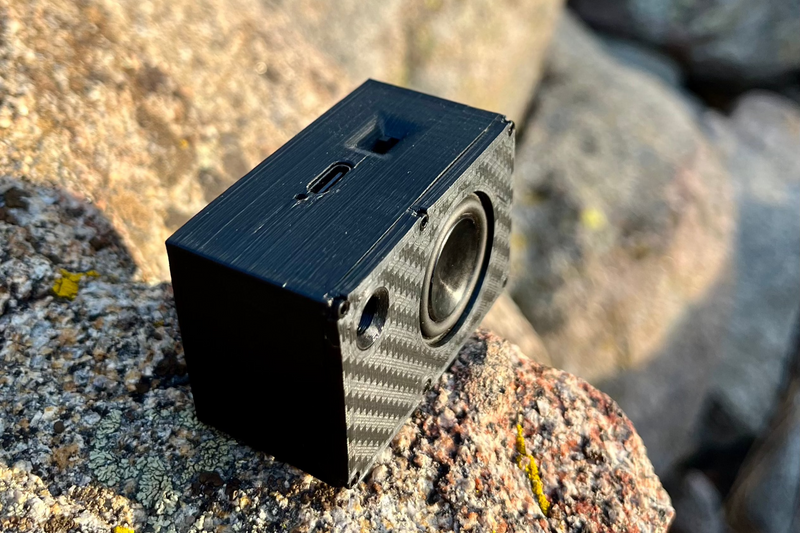 The Mini tipped up to show the USB-C charging port on the top of the box. Battery-powered, 1/24 and 1/18 scale.