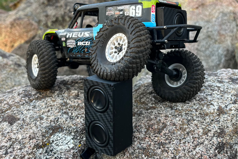 The Double stood on end beside a green and blue comp crawler on rock, drivers stacked one above the other. 1/24, 1/18 and 1/10 scale.