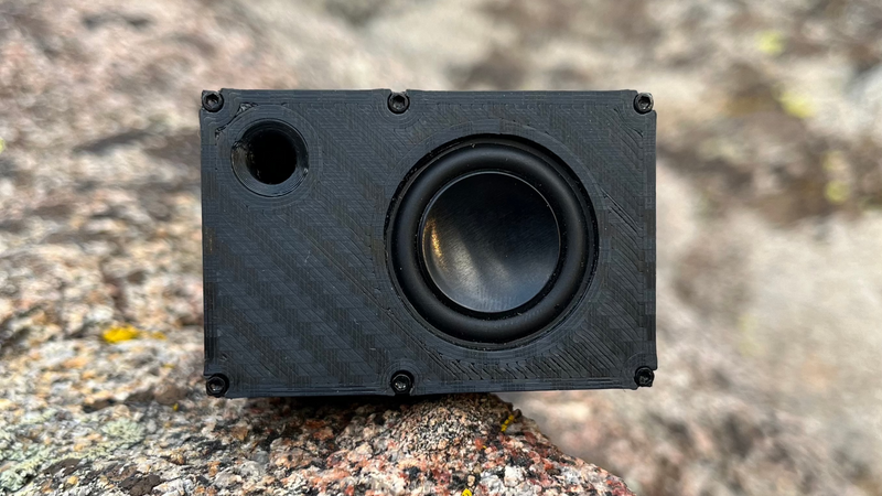 The Mini straight on against granite, port hole to the left of the driver. 1/24 and 1/18 scale RC speaker.