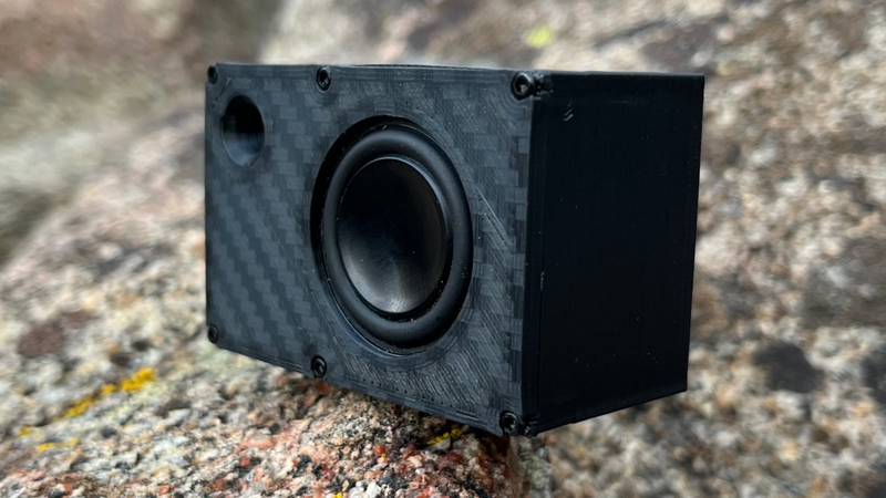 The Mini turned to show the carbon-look side panel and the full depth of the enclosure. 1/24 and 1/18 scale.