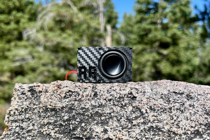 The Single face on with the embossed RR logo beside the driver, on a granite boulder with pines behind. 1/24 and 1/18 scale.