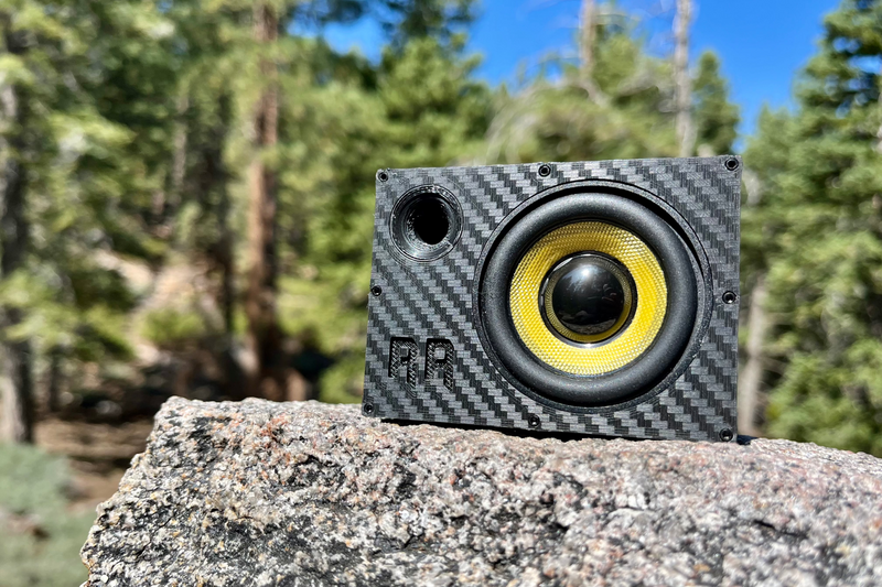 The Supreme Single with a yellow-cone 52 mm driver, on a granite boulder with pines behind. 1/10 scale.