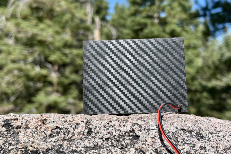 The Supreme Single from behind, carbon-look weave across the rear panel and the receiver lead running off the rock. 1/10 scale.
