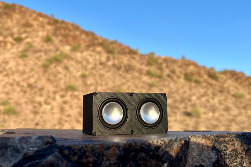 The Double face on atop a flat dark rock, both 1-inch drivers catching the light. 1/24, 1/18 and 1/10 scale.