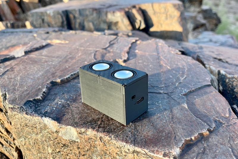 The Double at a high angle on flat rock with both drivers and the USB-C port on the end panel in frame. 1/24, 1/18 and 1/10 scale.