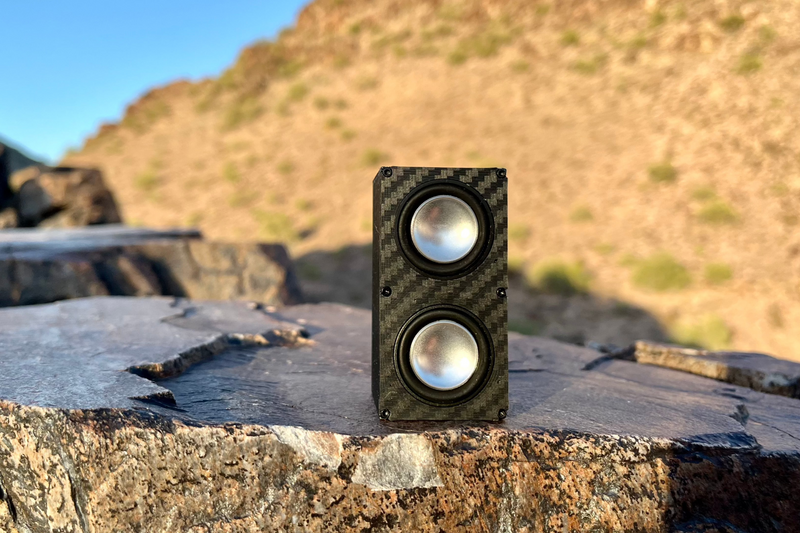 The Double stood upright on a rock ledge with a desert hillside behind. 1/24, 1/18 and 1/10 scale RC speaker.