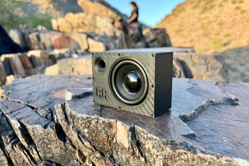 The Supreme Single standing on a flat rock slab with the black cone facing the camera. 1/10 scale RC speaker.