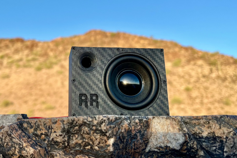 The Supreme Single face on with a black-cone driver and port, desert hillside behind. 1/10 scale RC speaker.