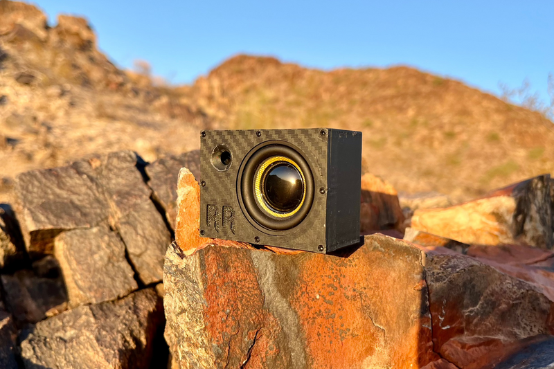 The Super Single with a yellow-cone 40 mm driver, sitting on orange desert rock. 1/10 scale RC speaker.