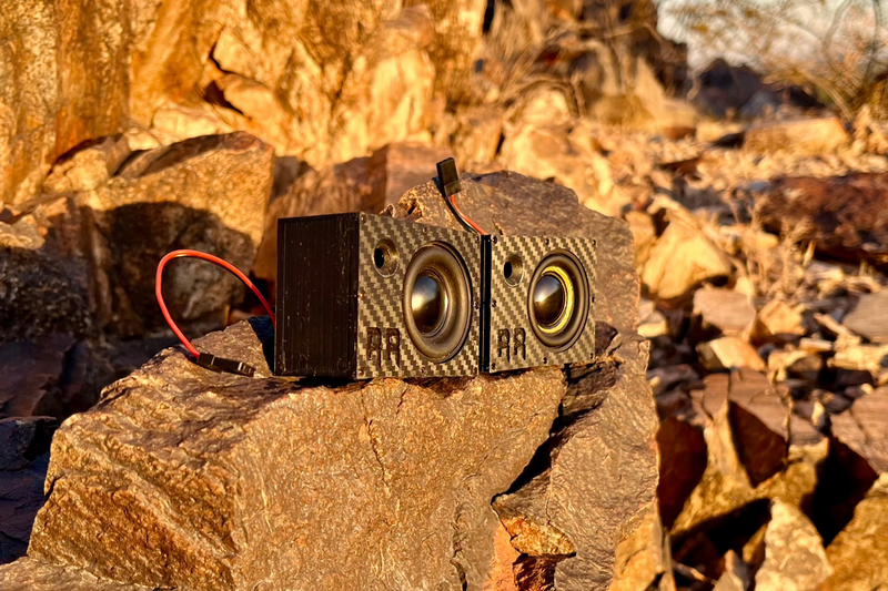 Two Super Single units side by side on desert rock, both with yellow-cone drivers and receiver leads. 1/10 scale.