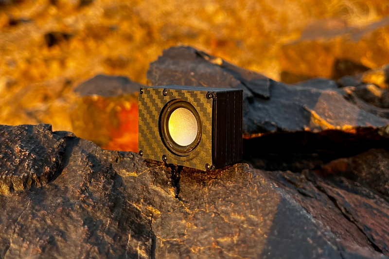 The Micro Single lit by low sun against dark rock, gold carbon-look face and single driver. 1/24 and 1/18 scale RC speaker.