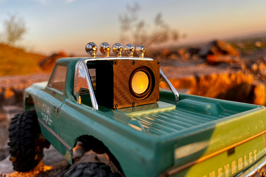 The Micro Single mounted in the bed of a green Chevrolet-bodied RC pickup with roof lights, on desert rock at sunset. 1/24 and 1/18 scale.