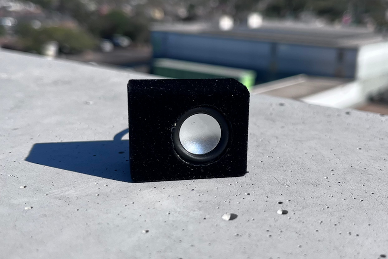 The Micro Single in black suede wrap, three-quarter front view showing the driver and the depth of the box. 1/24 and 1/18 scale.