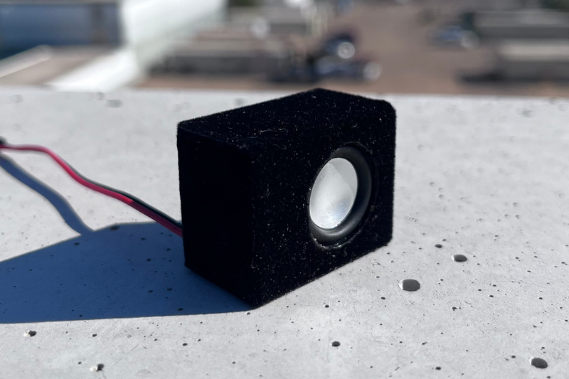 The Micro Single in black suede wrap at a low angle on concrete, receiver leads curling behind it. 1/24 and 1/18 scale.